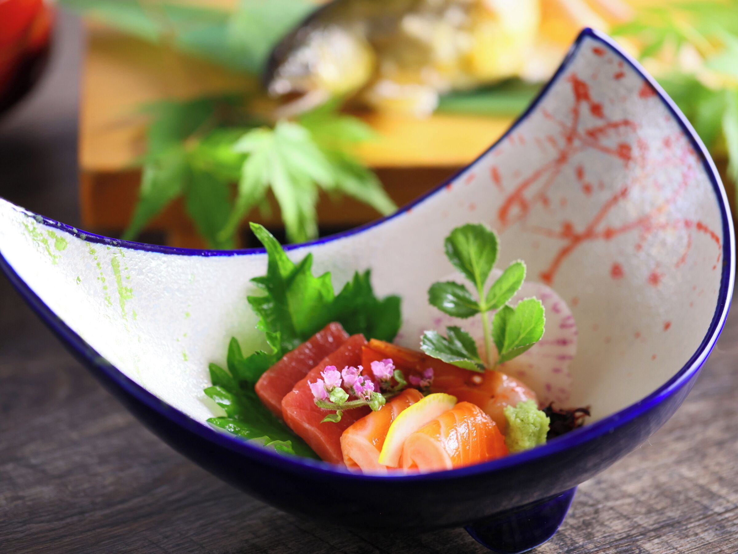 A bowl of food with salmon, lemon, and greens.