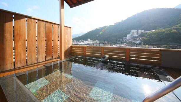 A wooden deck with a view of a city and mountains. - Ogiwarakan (Chikuma)