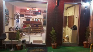 A hotel entrance with a reception desk, chairs, and a small reception area. - Taksim Palace Hotel (Istanbul)