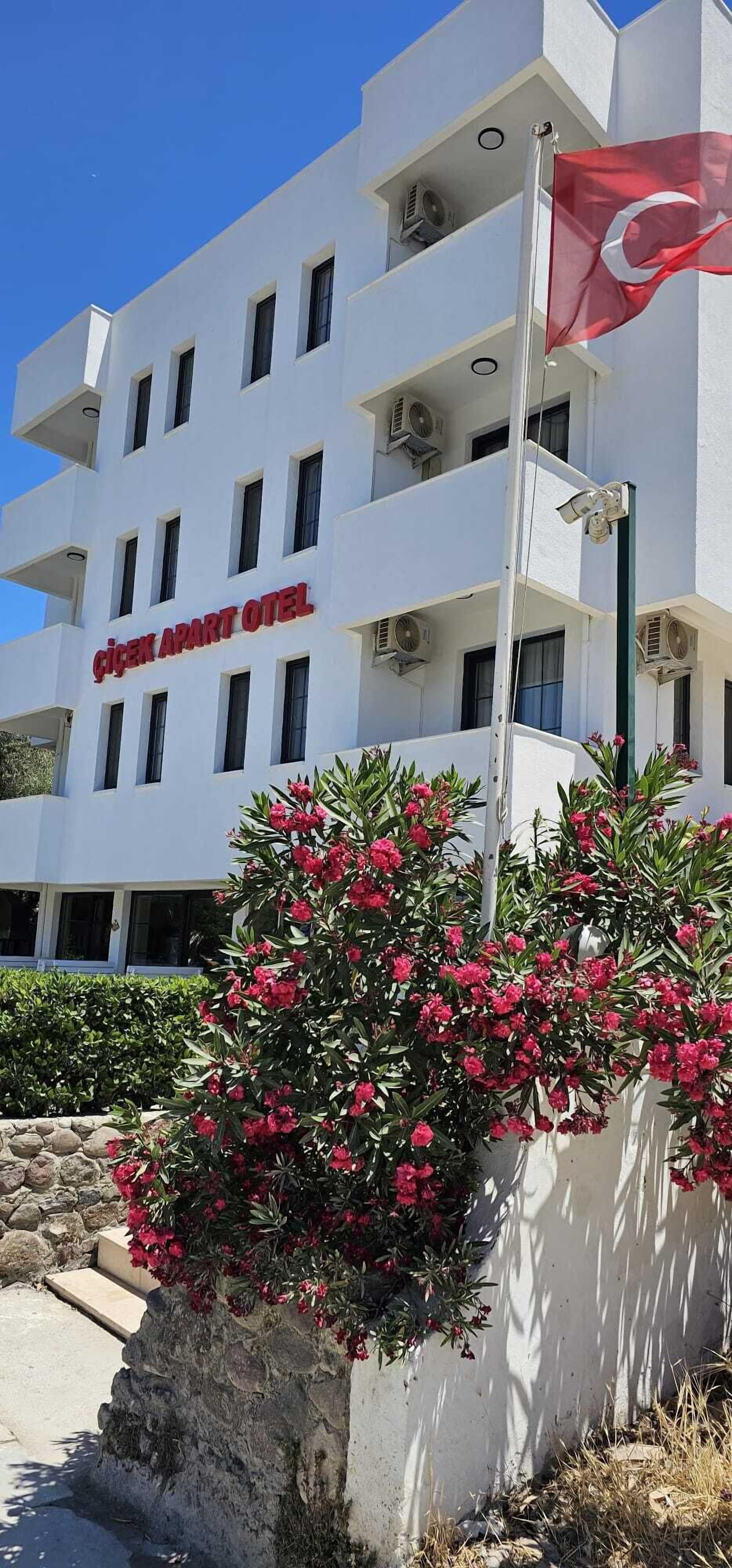 A white building with balconies and a flag.