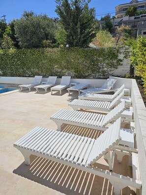 Una piscina al aire libre, tumbonas
