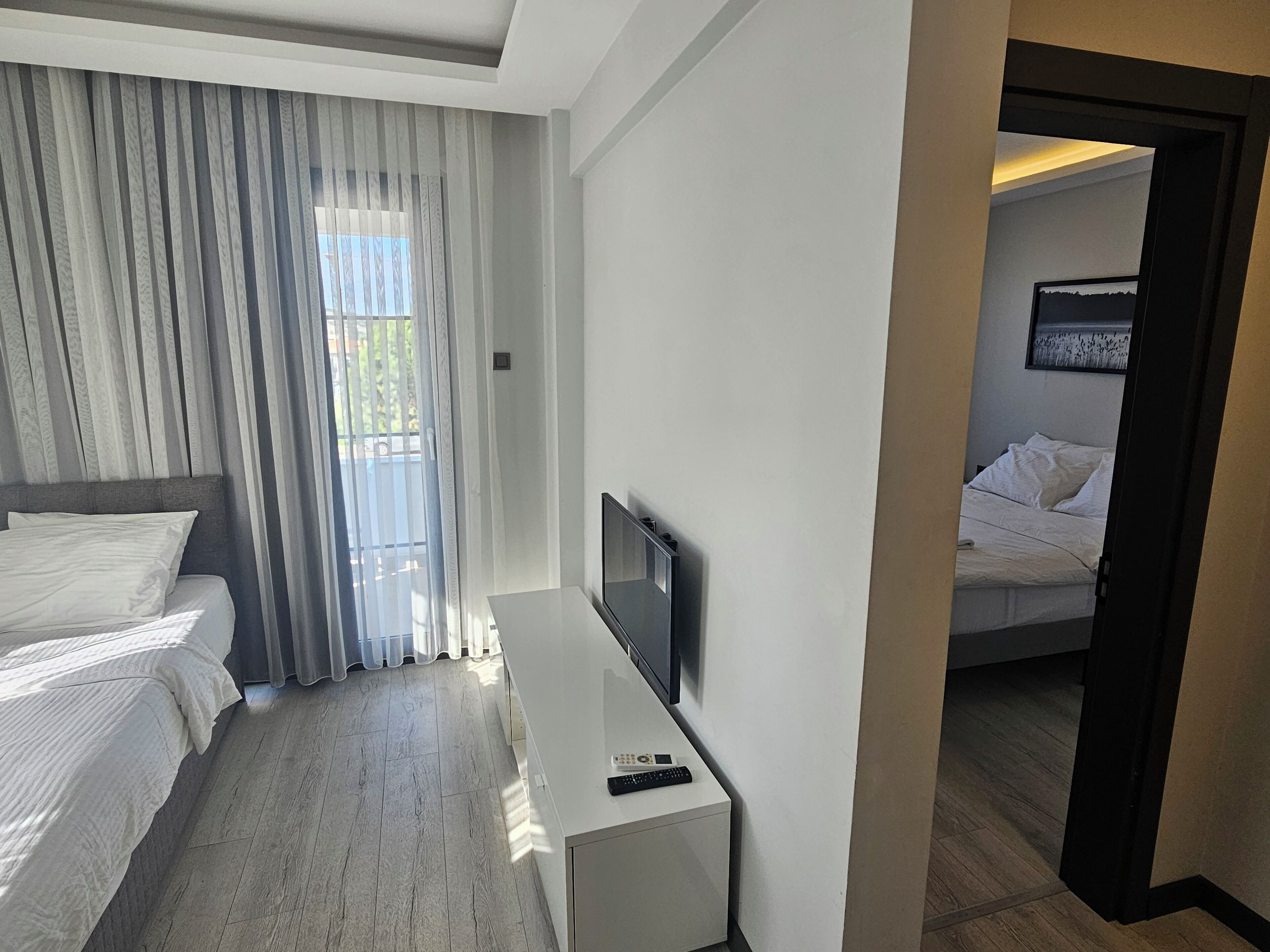 A hotel room with a bed, a TV, and a desk.