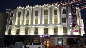 A hotel with a traditional architectural style, featuring arched windows and a prominent sign. - Nun Otel (Konya)