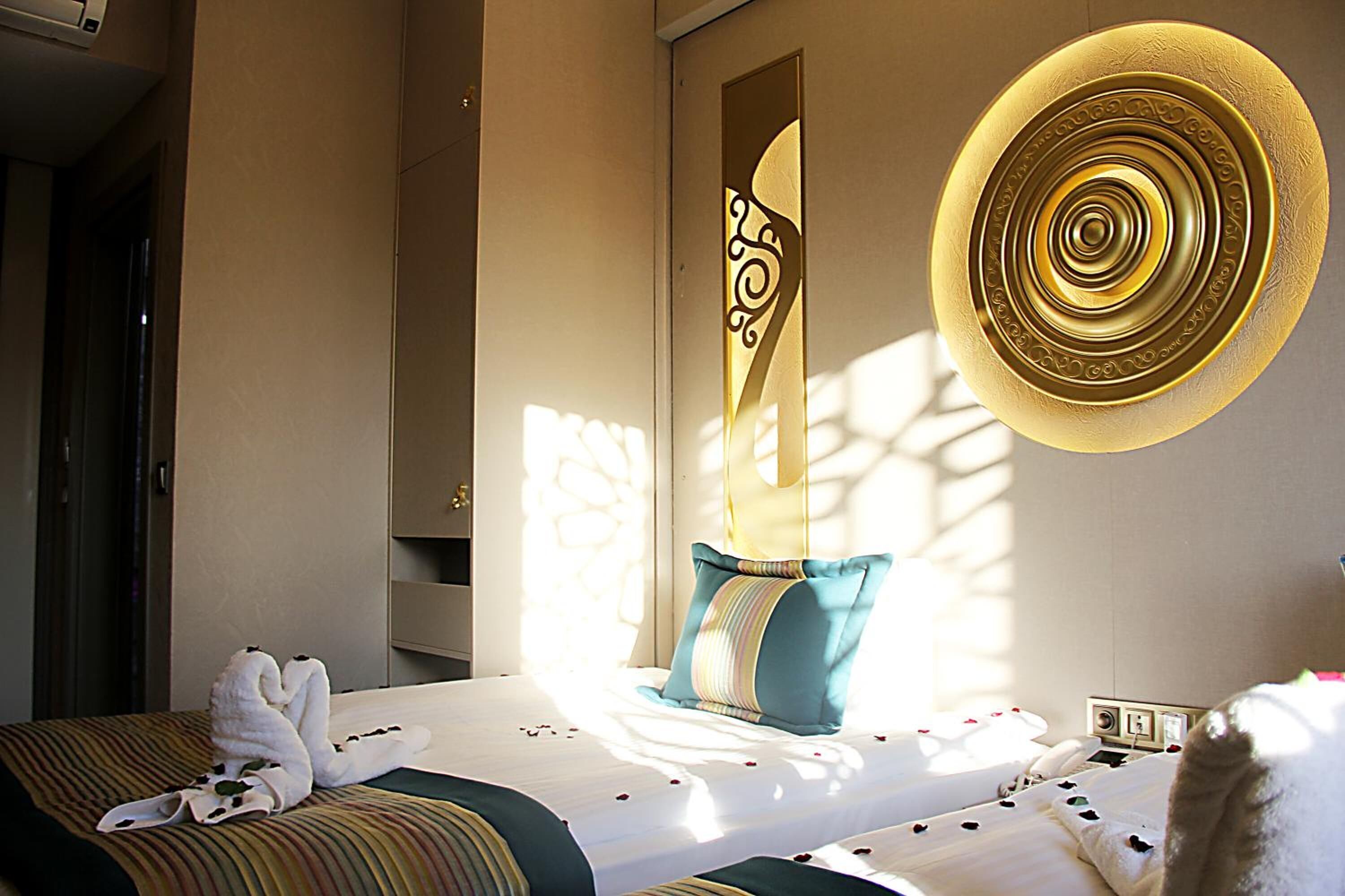Une chambre d’hôtel avec un lit, un élément décoratif mural et une table de chevet avec une lampe.