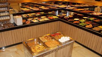 A buffet with various food items and a coffee station.