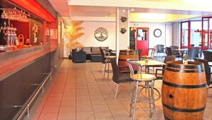 A restaurant with a bar area, seating, and decorative elements like a tree mural and a clock. - Azureva Tregunc (Tregunc)