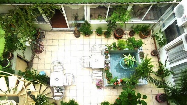 A patio with a pool, surrounded by potted plants and outdoor furniture. - Vatan Hotel (Izmir)