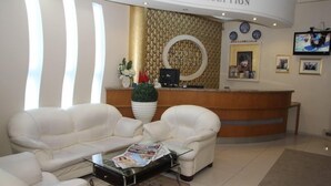 A reception area with a reception desk, a sofa, and a coffee table. - Vatan Hotel (Izmir)