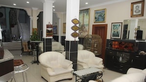 A living room with white leather sofas, a glass coffee table, and a black entertainment unit. - Vatan Hotel (Izmir)