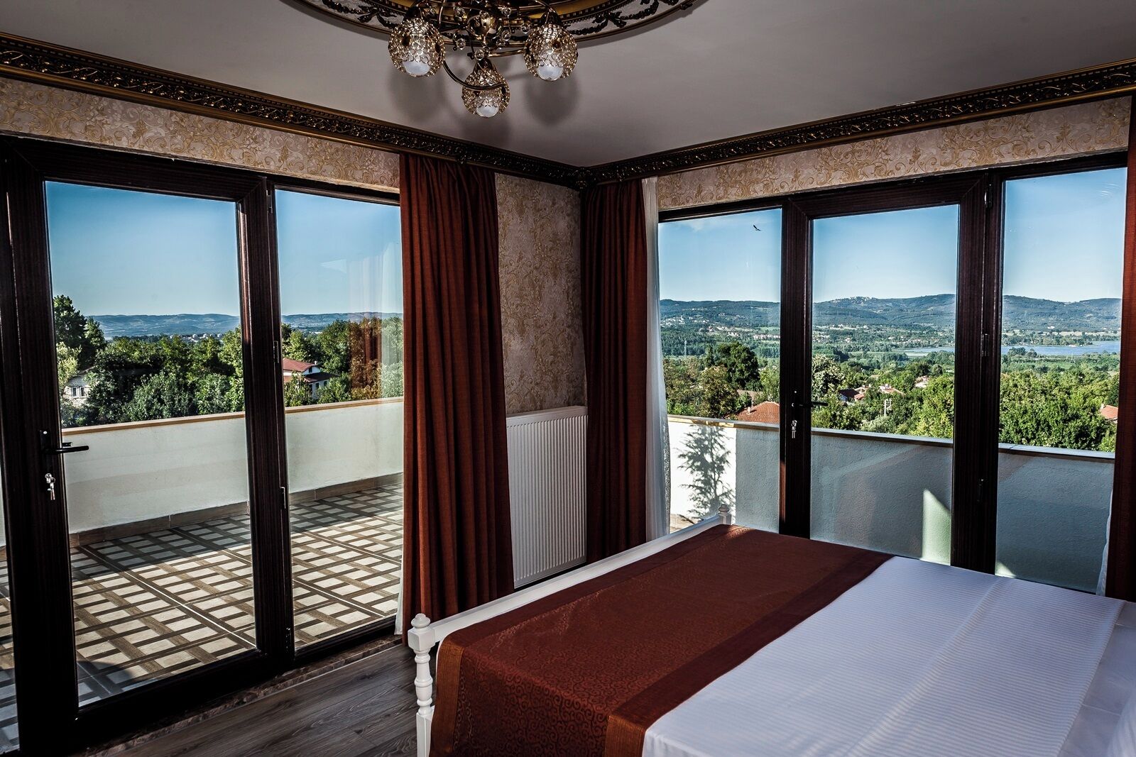 Habitación de hotel con una cama grande, vista al campo y un balcón.
