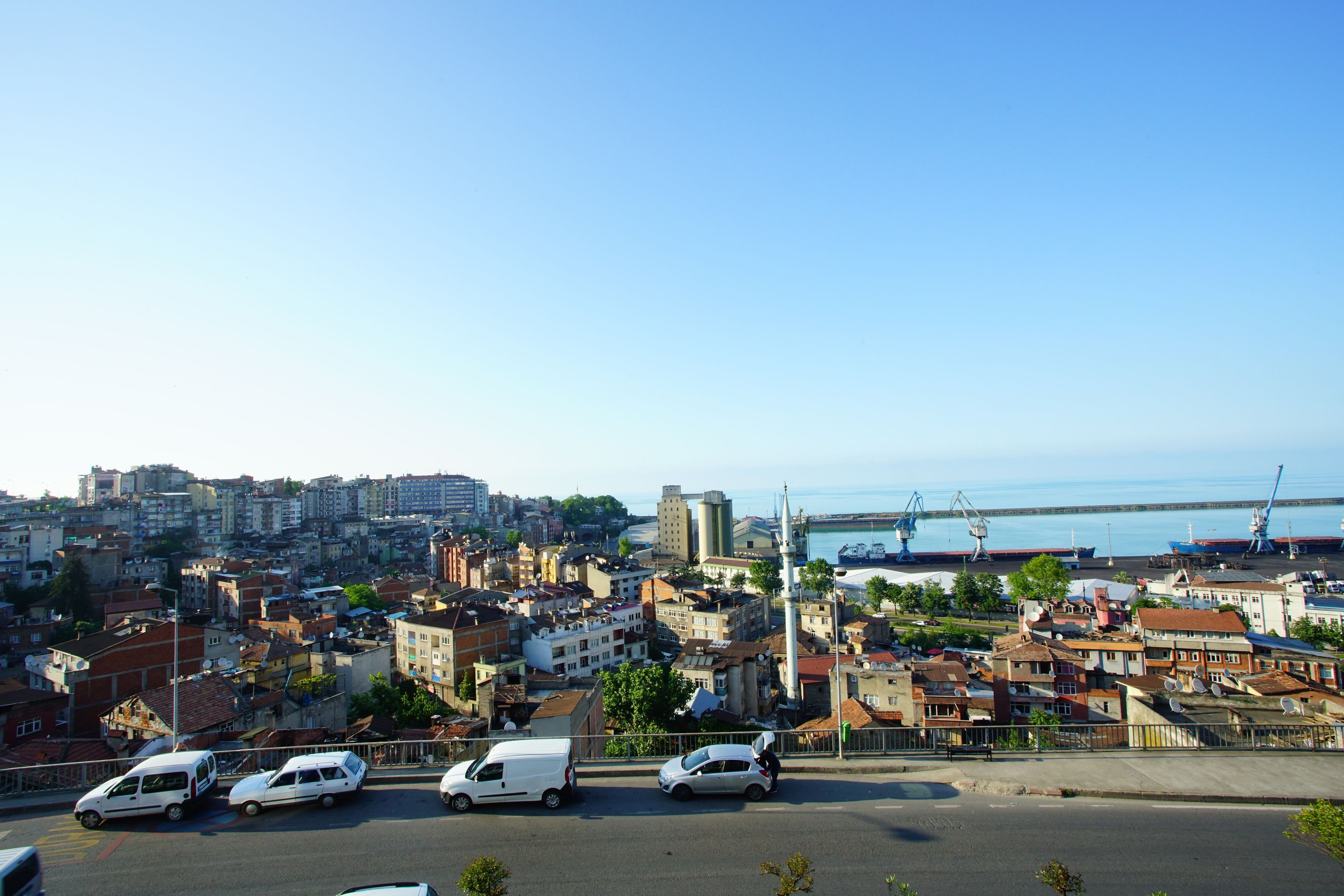 Panorama urbano con vista al puerto, que incluye edificios y coches estacionados.