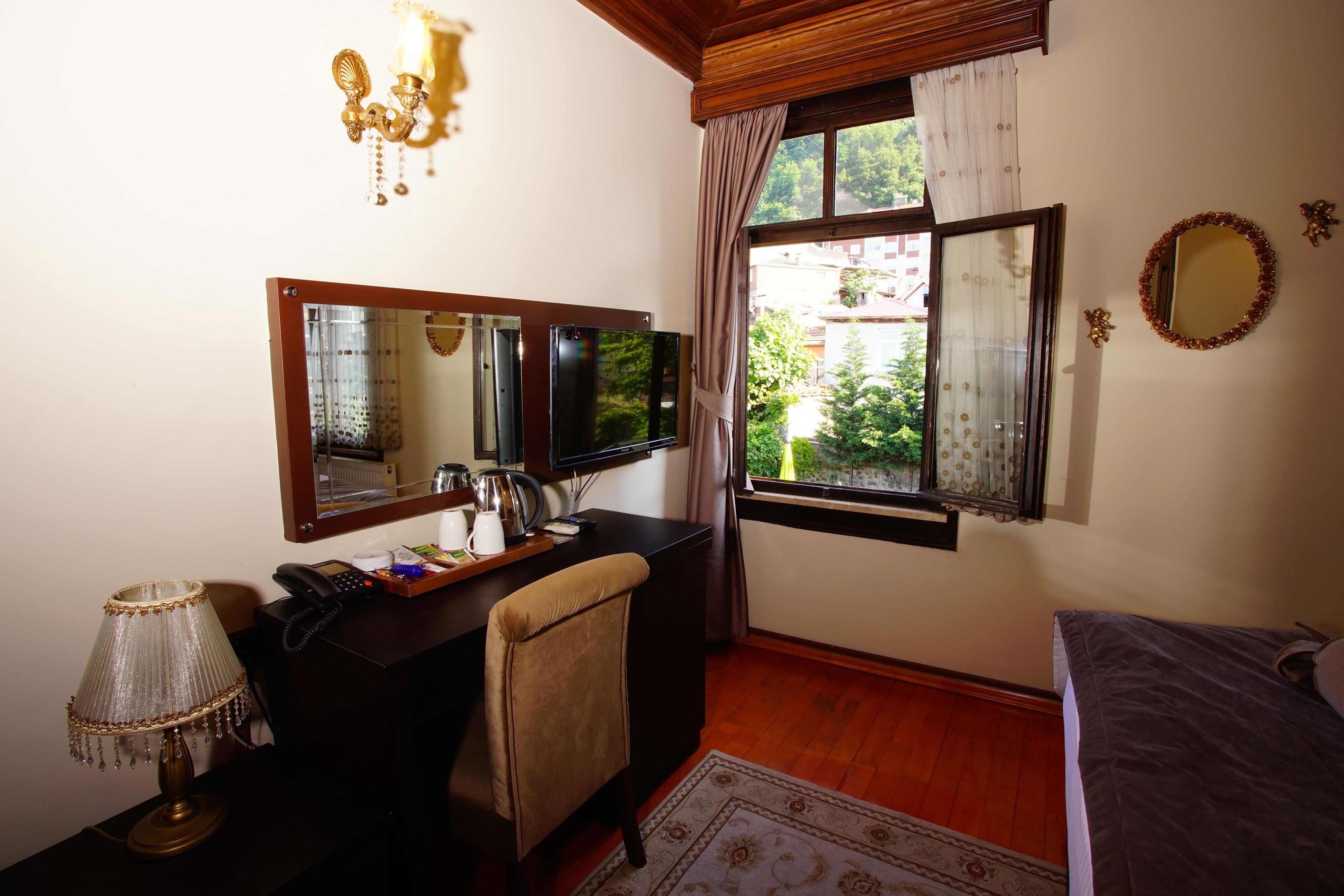Una habitación con escritorio, silla, cama y ventana con cortinas.