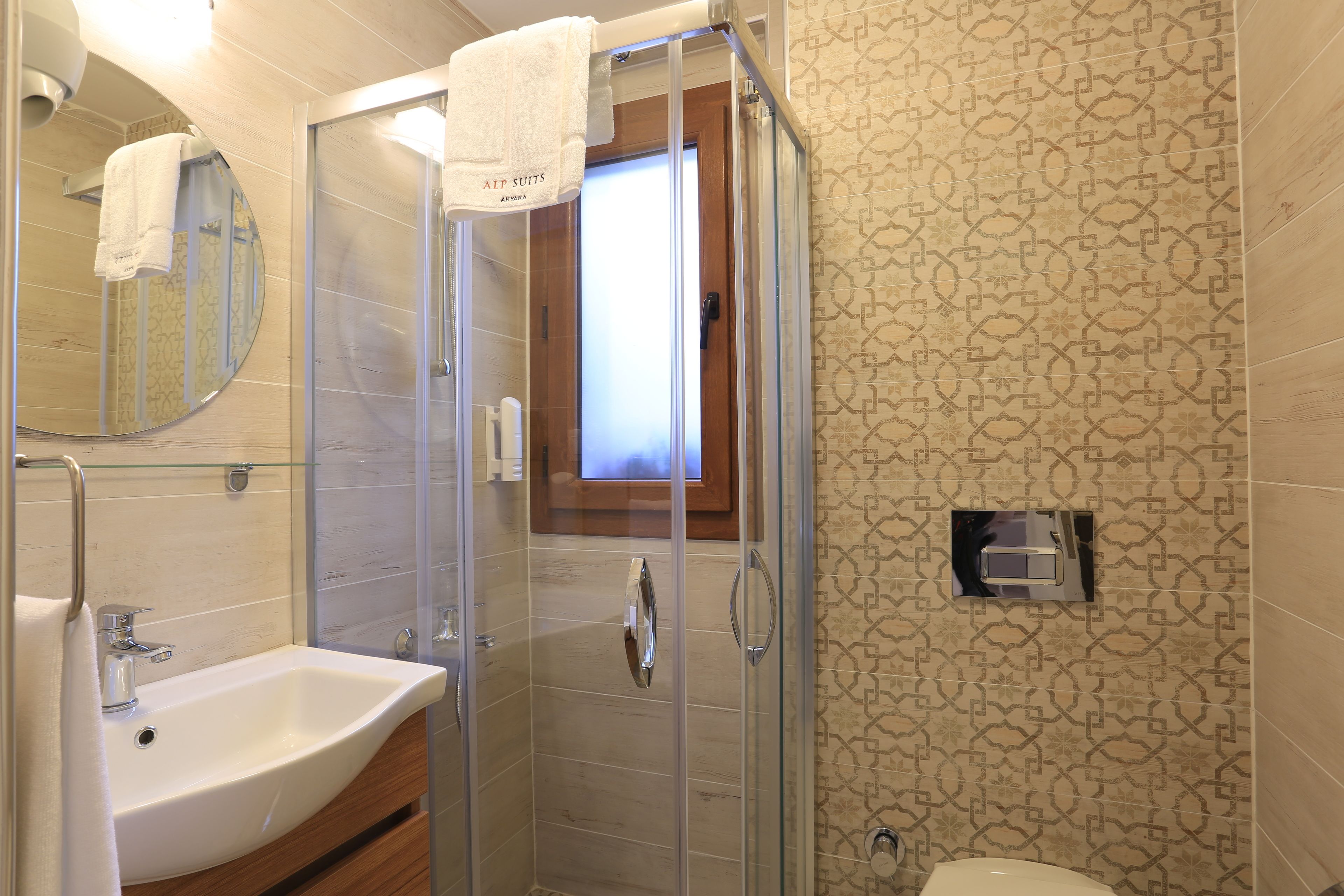 A modern bathroom with a glass-enclosed shower, a sink, and a toilet.