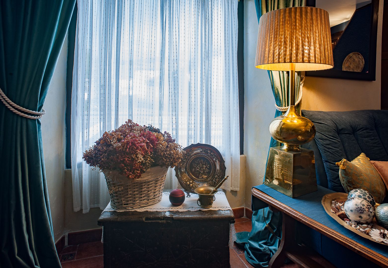 A cozy living room with a vintage lamp, a decorative basket, and a sofa.