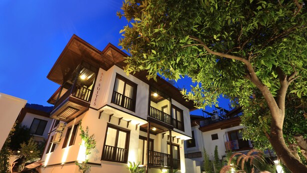 A two-story building with balconies, a scooter parked in front, and a tree in the foreground. - Alp Suites Mandalin (Ula)