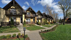 A row of yellow buildings with wooden balconies and a clear sky. - APLEND Villas Tatry Holiday (Velky Slavkov)