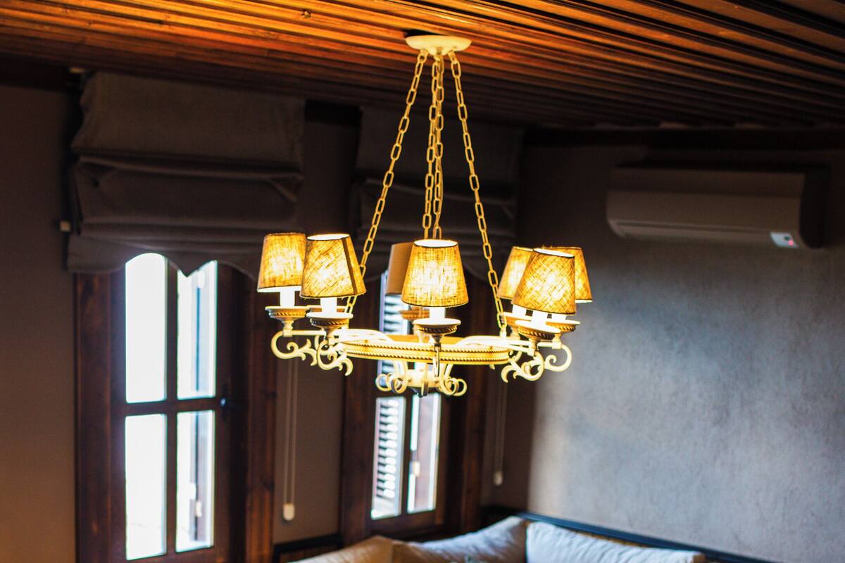 A cozy living room with a sectional sofa, a coffee table, and a unique chandelier.