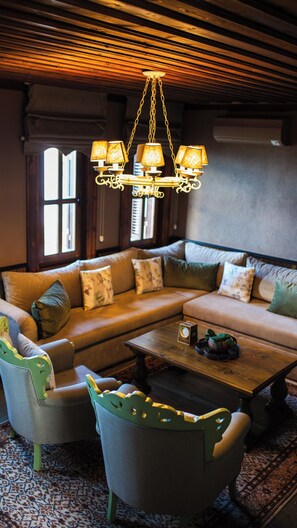 A cozy living room with a sectional sofa, a coffee table, and a unique chandelier. - Akcatepe Dag Evleri (Akçaabat)