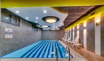 Una piscina techada, sillones reclinables de piscina