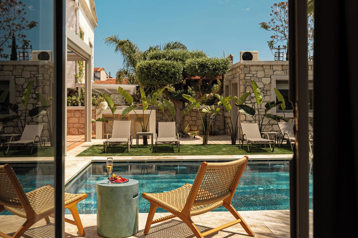 A pool area with lounge chairs and a clear view of a building in the background.