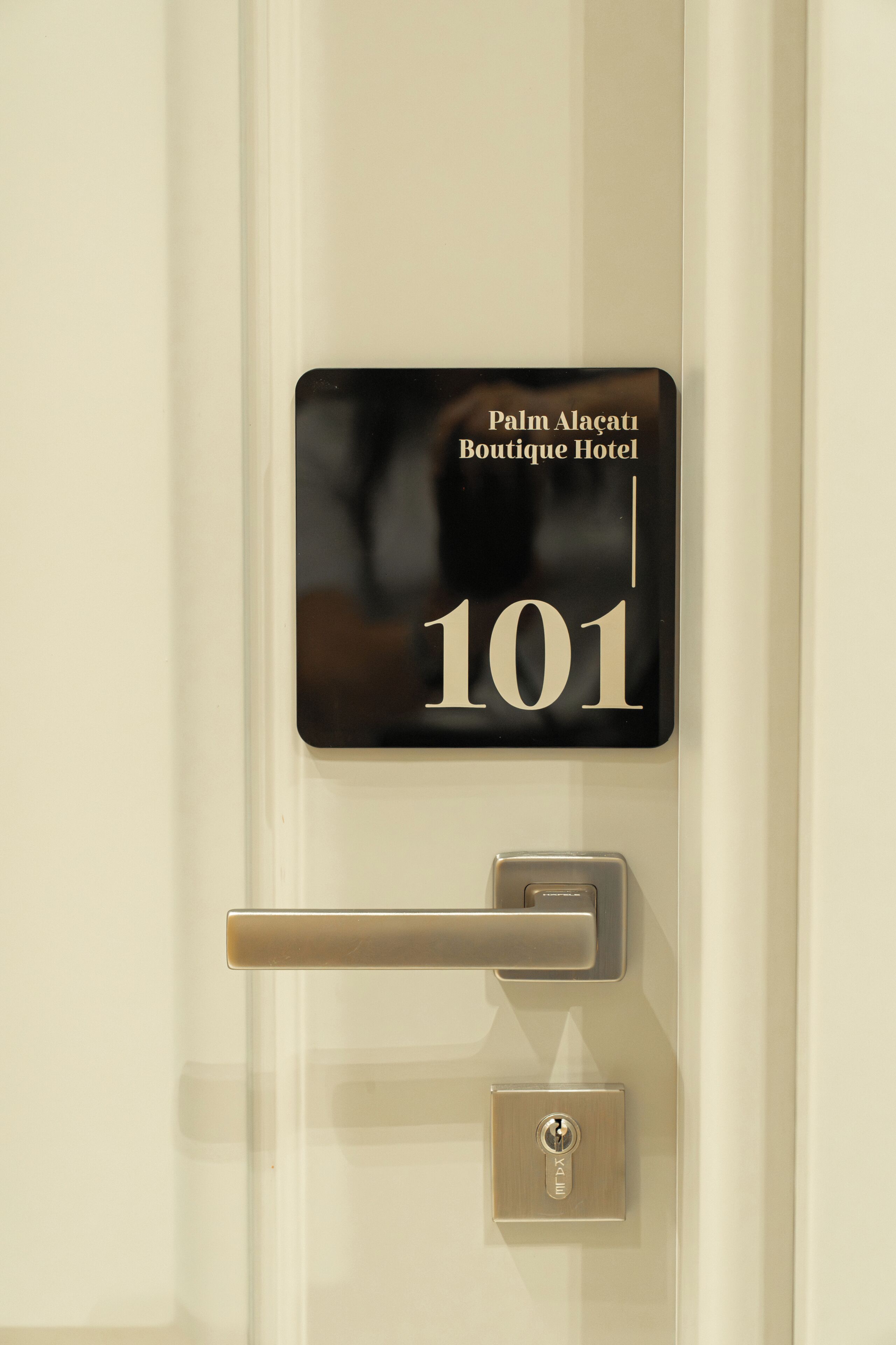 A door with a sign indicating 'Palm Alaçati Boutique Hotel 101.'