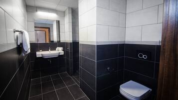 A modern bathroom with a sink, mirror, and toilet.