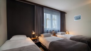 A hotel room with two beds, a large window with curtains, bedside lamps, and a framed picture on the wall. - Vulcan Hotel (Szczecin)