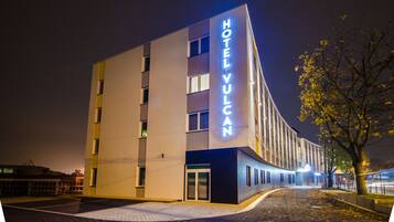 A modern hotel building with a prominent sign reading "HOTEL VULCAN".
