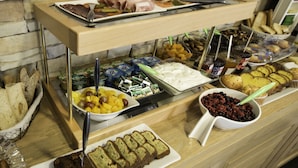 A buffet with various food items including fruits, breads, and desserts. - Un Hôtel sur le Port (La Rochelle)