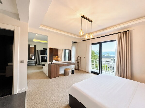 Una habitación de hotel moderna con una cama grande, un escritorio, un espejo y un balcón con vistas.