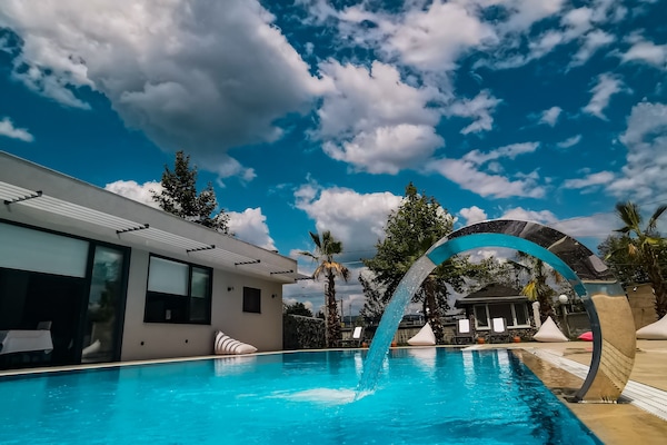 Una piscina al aire libre, sillones reclinables de piscina
