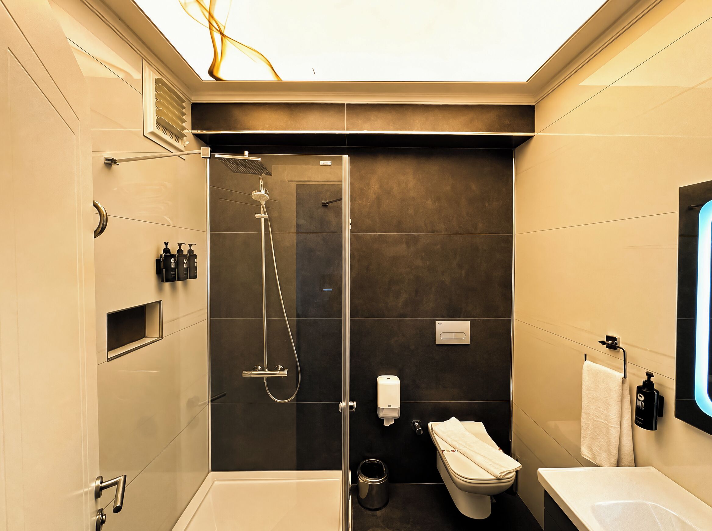Un baño moderno con ducha, inodoro y lavamanos.