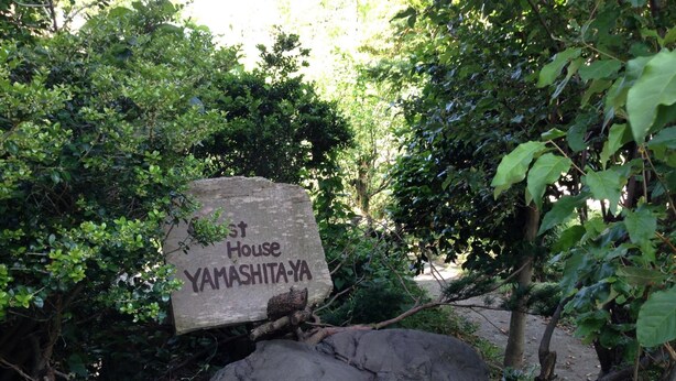 A stone sign with 'Yamashita-Ya' written on it, surrounded by greenery. - Guest House YAMASHITA-YA - Hostel (Nanto)