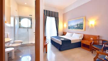 Une chambre d’hôtel avec un lit, une table de chevet, une chaise et un tableau au mur.