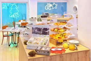Um buffet de café da manhã com diversos alimentos e uma placa indicando opções sem glúten.
