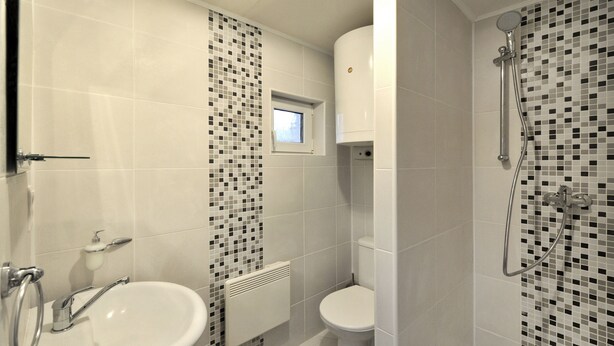 A bathroom with a white sink, toilet, and shower. - APLEND Chaty Lux Tatry Holiday (Velky Slavkov)