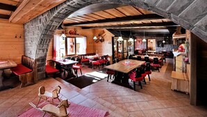 A rustic wooden interior with stone walls, wooden tables, and red upholstered chairs. - APLEND Chaty Lux Tatry Holiday (Velky Slavkov)