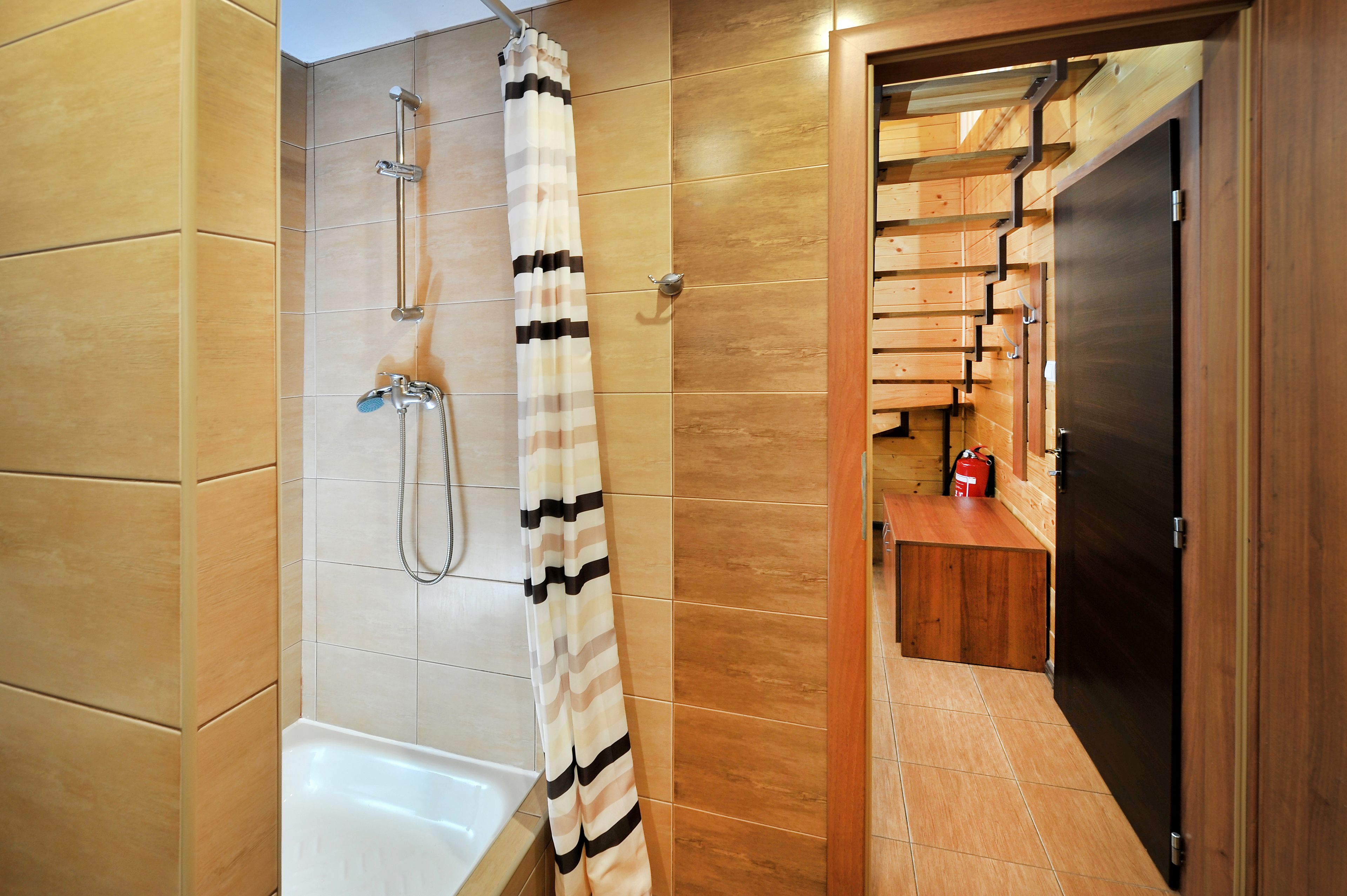 Une salle de bain moderne équipée d’une douche, d’une baignoire et d’un meuble-lavabo en bois avec un miroir.