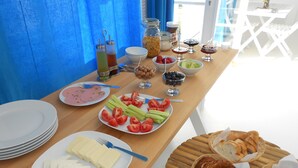 Um buffet de café da manhã com diversos alimentos e utensílios.