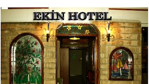 L'entrada de l'Hotel Ekin, amb dues finestres de vitralls i façana de maó.