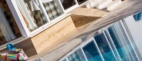 Alberca al aire libre, sombrillas en la alberca y camastros