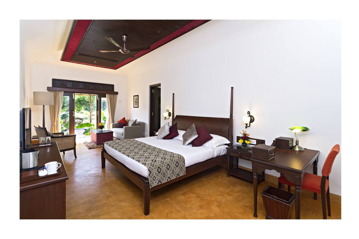 Um quarto espaçoso com uma cama grande, uma escrivaninha e uma cadeira.