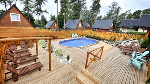 A wooden deck with a pool, lounge chairs, and a wooden pergola. - APLEND Domčeky Tatry Holiday (Velky Slavkov)