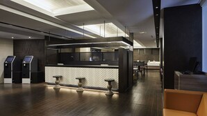 A modern hotel lobby with a reception desk, seating area, and a view of the cityscape. - Viainn Shinsaibashi (Osaka)