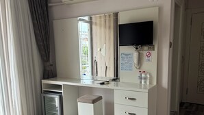A hotel room with a bed, a desk, a television, a minibar, and a bathroom. - Send Apart Otel (Konyaalti)