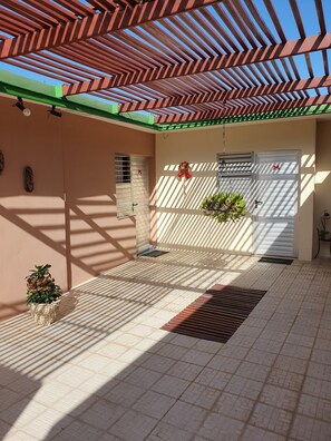 Relax in this serene outdoor space with a potted plant and a small table.
