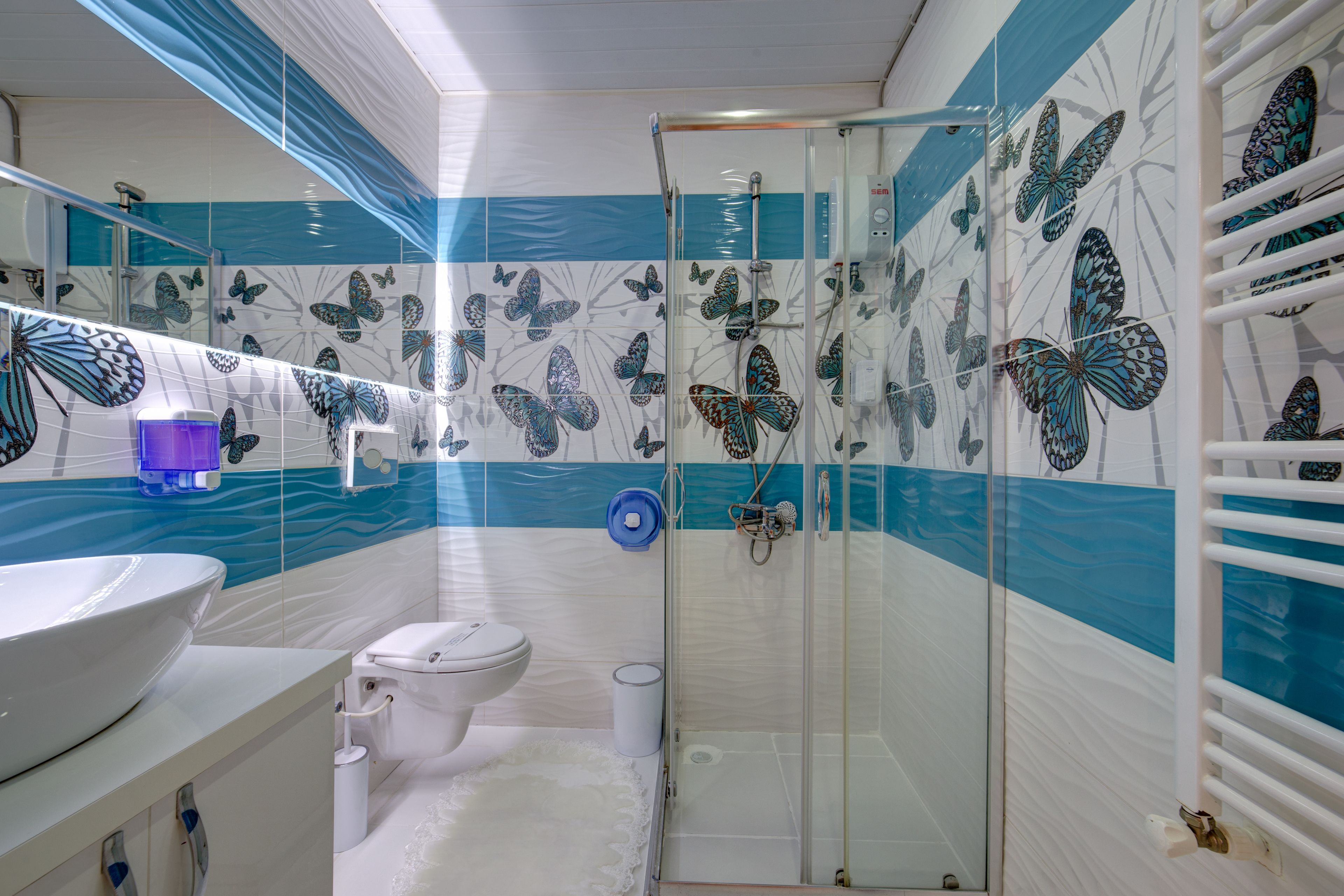 Un baño con cabina de ducha de vidrio, inodoro y lavabo.