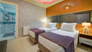 A hotel room with two beds, a shower area, a wooden headboard, and a mirror. - Mersin Vip House (Mezitli)