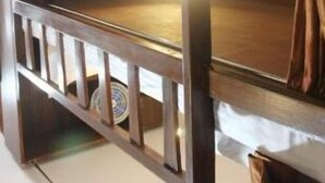 A bunk bed with a headboard, a pillow, and a small shelf. - Awesome Dormitory (Mumbai)