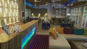 A modern interior with a reception desk, seating area, and bar. - Ocean Retreat & Spa (Guraidhoo)